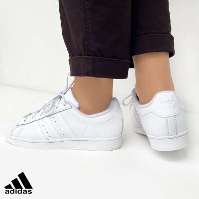 Ténis brancos Adidas SuperStar com três riscas e logótipo em relevo no calcanhar