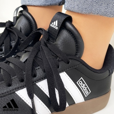 Ténis Adidas pretos com riscas brancas e solado castanho claro