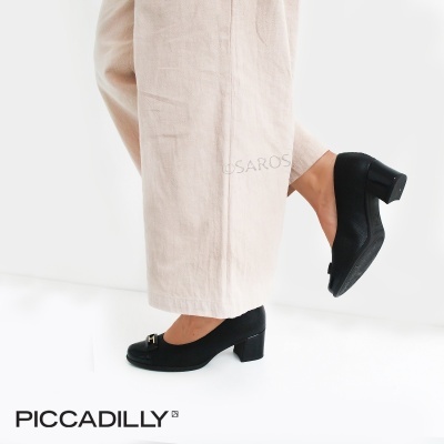 Sapatos pretos de salto médio com detalhe metálico usados com calças largas bege