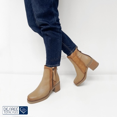 Botas de couro bege com tacão médio e fecho de correr, usadas com calças de ganga azuis