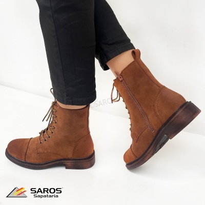 Botas castanhas em camurça com atacadores e fecho lateral exibidas com calças pretas