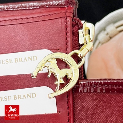 Saco vermelho de couro com pendente dourado de cavalo e etiquetas PORTUGUESE BRAND