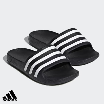 Chinelos Adidas pretos com riscas brancas sobre fundo branco