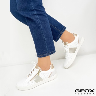 Ténis brancos com detalhes prateados usados com calças de ganga azul