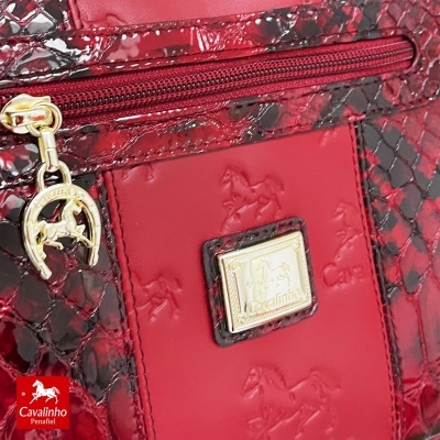Mala de mão vermelha com padrão escamas, pendente e placa dourada com cavalo e texto Cavalinho
