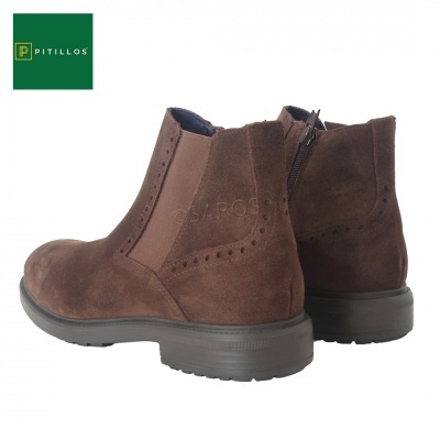 Botas Chelsea castanhas em camurça com fecho e elásticos laterais, logotipo Pitillos verde e branco ao fundo