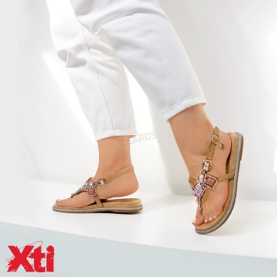 Sandálias bege com pedras decorativas e fivela dourada, usadas com calças brancas