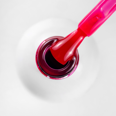 Pincel de verniz de unha vermelho visto de cima num frasco transparente