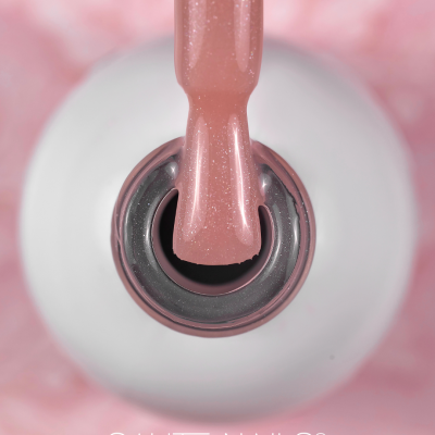 Frasco de verniz de unhas branco com verniz rosa cintilante e texto SAUTE NAILS®