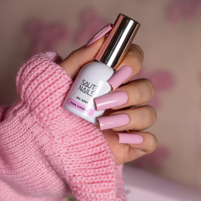 Unha com verniz rosa claro segurando frasco de verniz SAUTE NAILS PINK COOKIE