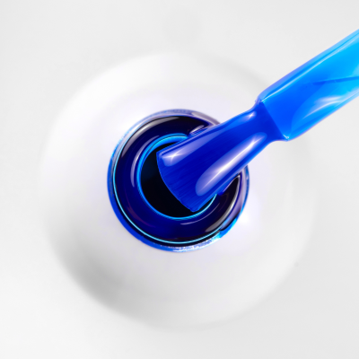 Pincel azul num frasco branco de verniz de unhas azul escuro com texto SAUTE NAILS®