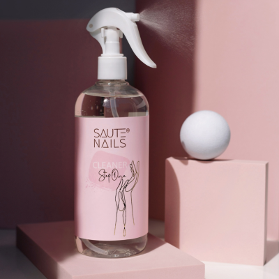 Frasco spray transparente com rótulo rosa sobre superfícies geométricas cor-de-rosa e branca