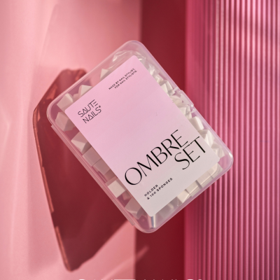 Estojo transparente com esponjas brancas e etiqueta rosa com texto preto de unhas