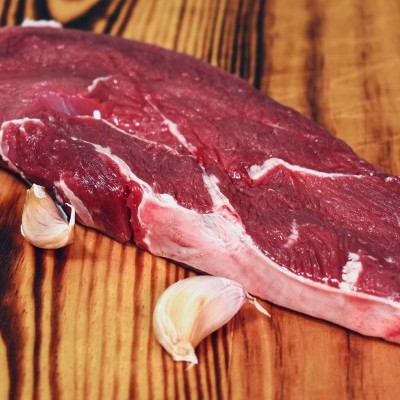 Carne crua vermelha com dentes de alho sobre tábua de madeira