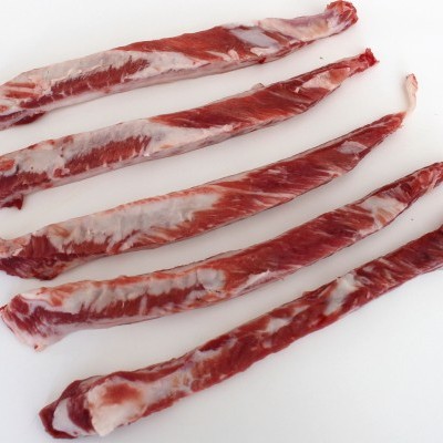 Tiras longas de carne crua com gordura sobre superfície branca