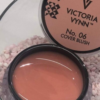 Frasco de blush cremoso cor pêssego da Victoria Vynn com tampa e texto visível.