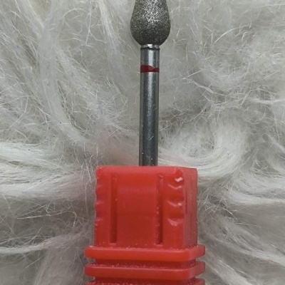 Broca rotativa metálica com ponta abrasiva e base vermelha sobre fundo branco felpudo