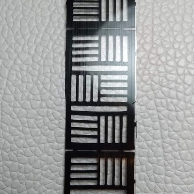 Fita preta com cortes em linhas sobre fundo branco texturizado