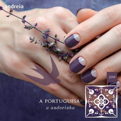 Mãos femininas com unhas pintadas em roxo escuro e meia-lua prateada segurando ramo de flores secas
