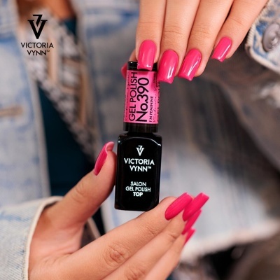 Frasco de verniz de gel Victoria Vynn com texto em rosa e preto, mãos segurando com unhas rosa