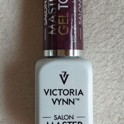 Frasco de verniz gel branco com tampa castanha com texto preto.