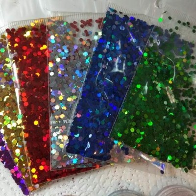 Seis sacos transparentes com lantejoulas coloridas brilhantes sobre superfície branca