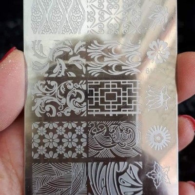 Placa metálica prateada com gravuras decorativas variadas