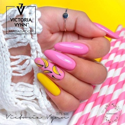 Mão com unhas decoradas em rosa e amarelo segurando canudos rosa e brancos