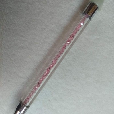 Caneta transparente com cristais rosa dentro e tampa cinzenta