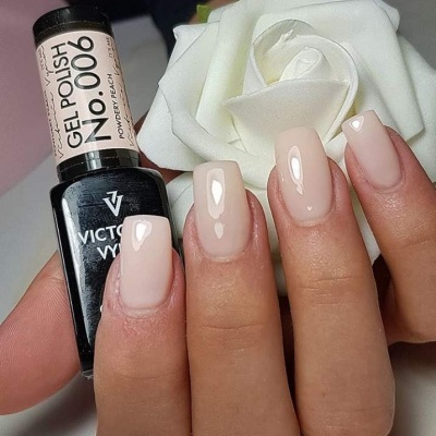 Mãos com unhas pintadas rosa claro brilhante seguram verniz em gel preto VICTORY NO.000 e rosa branca de tecido