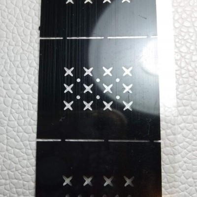 Três placas pretas com perfurações em X e pontos sobre fundo branco texturizado