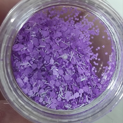 Frasco de vidro com confeites decorativos roxos variados