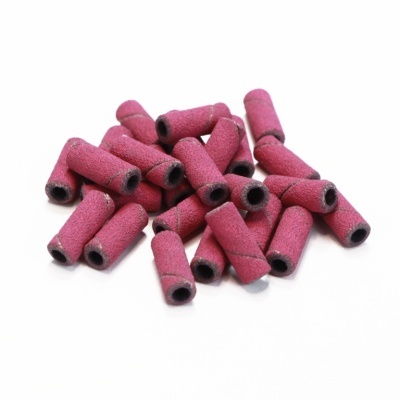 Pequenas lixas cilíndricas vermelhas para polimento sobre fundo branco