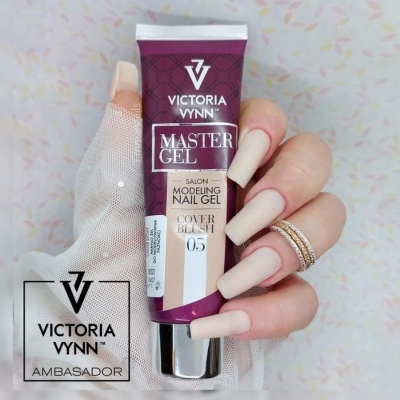 Mão com unhas em gel nude segurando tubo de gel para unhas Victoria Vynn Master Gel