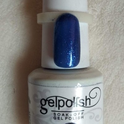 Frasco de verniz gel branco com amostra de unha azul brilhante