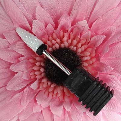 Broca para unhas branca e preta sobre flor rosa artificial