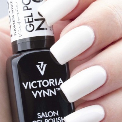 Frasco de verniz gel Victoria Vynn preto com texto branco e unhas brancas compridas