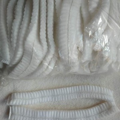 Elásticos brancos frisados em embalagem plástica sobre superfície clara