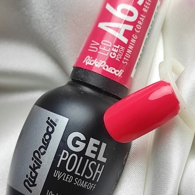 Frasco de verniz gel preto com tampa rosa e amostra de cor coral