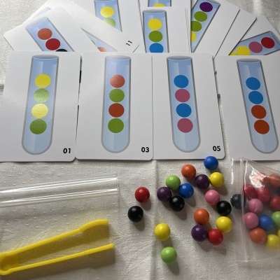 Cartas e contas coloridas com ferramentas em superfície cinzenta