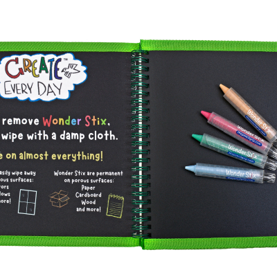 Livro de folhas pretas com capa verde e canetas coloridas