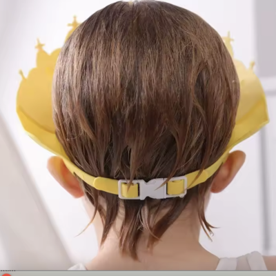 criança de cabelo castanho usando coroa amarela ajustável vista de costas