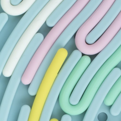 Tubos coloridos de silicone ou borracha macia em arranjo abstrato sobre superfície azul claro