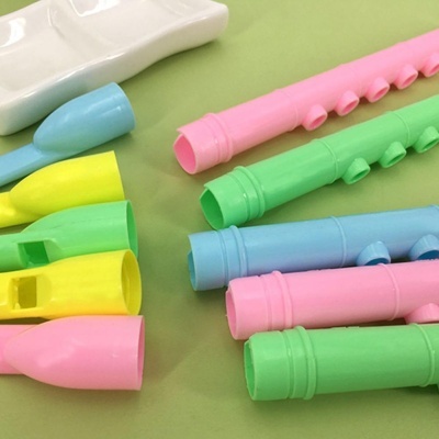 Blocos de construção de plástico coloridos em várias formas e cores sobre fundo verde.