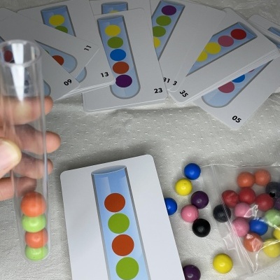Cartas e bolas coloridas com tubo de ensaio transparente contendo bolas dentro