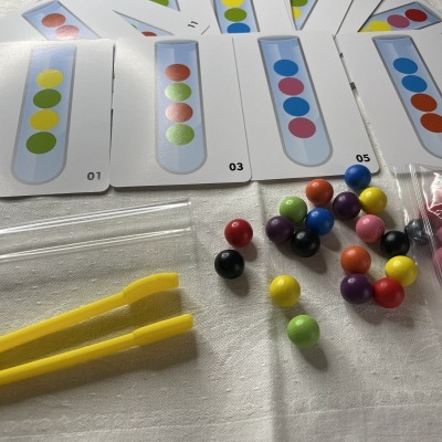 Jogo de lógica com bolas coloridas, cartas numeradas e pegador amarelo