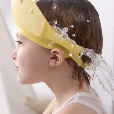 Criança com faixa amarela em forma de coroa a proteger o rosto da água