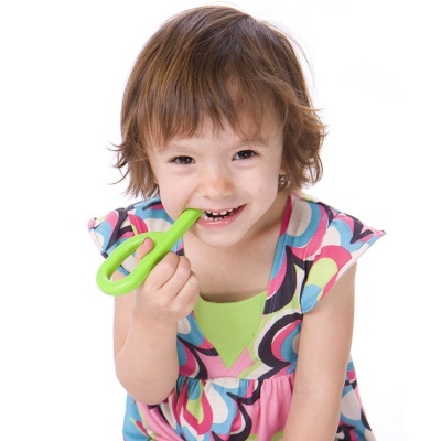 Menina a brincar com tesoura de plástico verde