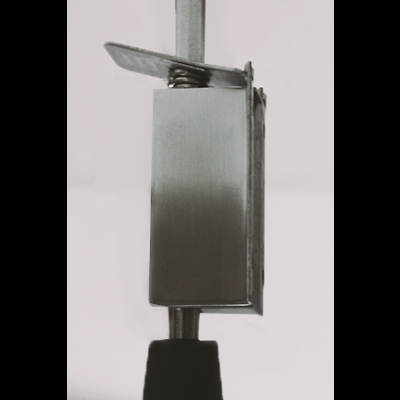 Fecho metálico prateado com mola e base preta sobre superfície branca