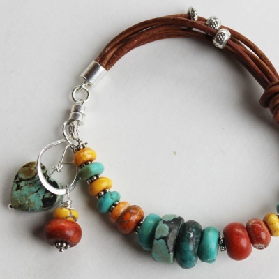 Pulseira com contas coloridas e pingente de coração em fundo branco